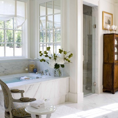 Alcove shower - traditional white tile marble floor alcove shower idea in Dallas with dark wood cabinets and an undermount tub