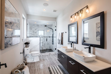 Diseño de cuarto de baño principal moderno grande con armarios con paneles lisos, suelo de baldosas de porcelana, lavabo sobreencimera y encimera de cuarzo compacto