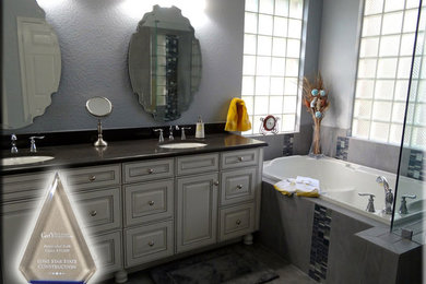 Drop-in bathtub - mid-sized transitional master gray tile and porcelain tile porcelain tile drop-in bathtub idea in Austin with raised-panel cabinets, white cabinets, granite countertops and gray walls