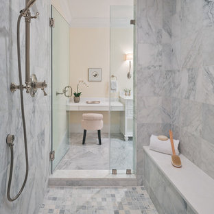 Example of a transitional master marble tile marble floor bathroom design in DC Metro with white cabinets and a hinged shower door