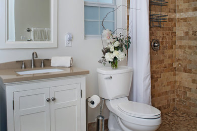 Foto de cuarto de baño tradicional renovado con armarios estilo shaker, puertas de armario blancas, sanitario de dos piezas, baldosas y/o azulejos beige, suelo de baldosas de porcelana, lavabo encastrado y encimera de acrílico