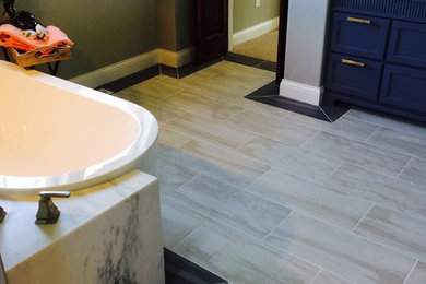 Large transitional master beige floor freestanding bathtub photo in Minneapolis with shaker cabinets, black cabinets, gray walls and an undermount sink