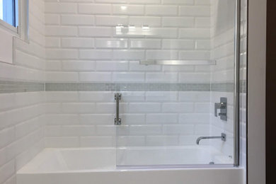 Example of a mid-sized master white tile and ceramic tile porcelain tile, white floor and single-sink bathroom design in Toronto with recessed-panel cabinets, white cabinets, a one-piece toilet, white walls, an integrated sink, granite countertops, a hinged shower door, white countertops and a freestanding vanity