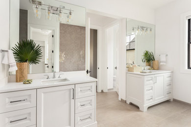Ispirazione per una stanza da bagno classica con ante con riquadro incassato, ante bianche, pareti bianche, lavabo sottopiano, pavimento grigio e top bianco