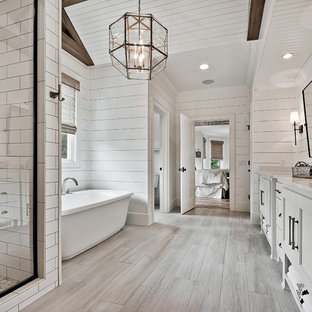 Idee per una stanza da bagno country con ante con riquadro incassato, ante bianche, vasca freestanding, pareti bianche, lavabo sottopiano, pavimento grigio e top bianco