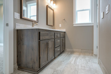 Example of a mid-sized transitional master ceramic tile and beige floor bathroom design in Portland with shaker cabinets, dark wood cabinets, beige walls, an undermount sink, quartzite countertops and white countertops