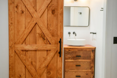 小さなコンテンポラリースタイルのおしゃれなマスターバスルーム (中間色木目調キャビネット、オープン型シャワー、白いタイル、磁器タイル、ベッセル式洗面器、木製洗面台) の写真