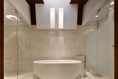 Exemple d'une grande salle de bain principale moderne en bois foncé avec un lavabo intégré, un placard à porte plane, une baignoire indépendante, une douche à l'italienne, WC à poser, un carrelage beige, des carreaux de porcelaine, un mur blanc, un sol en bois brun, un plan de toilette en quartz modifié et une cabine de douche à porte coulissante.