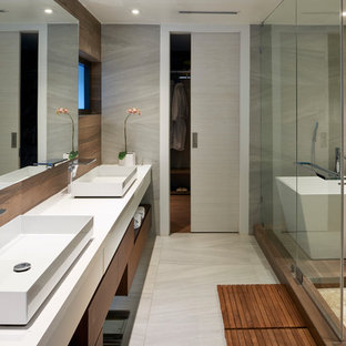 Ejemplo de cuarto de baño principal, contemporáneo, con armarios con paneles lisos, puertas de armario de madera oscura, bañera exenta, baldosas y/o azulejos grises, baldosas y/o azulejos de cerámica, paredes grises, lavabo sobreencimera, encimera de cuarzo compacto y ducha con puerta corredera