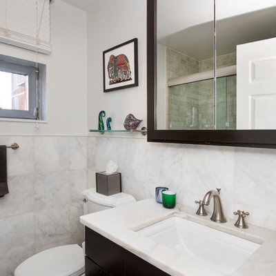 Inspiration for a small timeless 3/4 stone tile marble floor doorless shower remodel in New York with flat-panel cabinets, dark wood cabinets, a one-piece toilet, white walls, an undermount sink and marble countertops