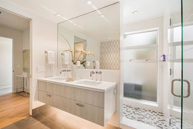 Corner shower - mid-sized modern master porcelain tile and gray floor corner shower idea in San Francisco with white walls, an undermount sink, a hinged shower door, flat-panel cabinets, light wood cabinets and marble countertops
