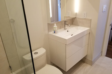 Example of a small minimalist beige tile and porcelain tile porcelain tile and beige floor bathroom design in Toronto with flat-panel cabinets, white cabinets, a one-piece toilet, quartzite countertops and white countertops
