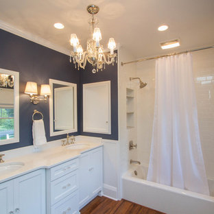 This is an example of a large transitional kids bathroom in Other with raised-panel cabinets, white cabinets, an alcove tub, a shower/bathtub combo, a two-piece toilet, white tile, ceramic tile, blue walls, bamboo floors, an undermount sink, granite benchtops, brown floor and a shower curtain.