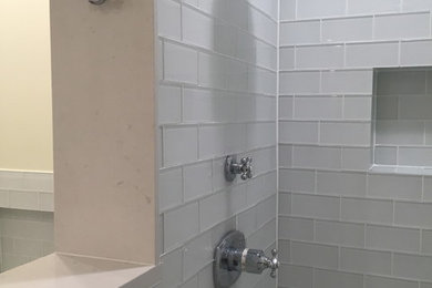 Example of a mid-sized trendy master white tile and glass tile travertine floor alcove shower design in Chicago with shaker cabinets, white cabinets, an undermount tub, a wall-mount toilet, white walls, an undermount sink and quartzite countertops