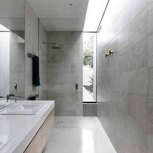 Ispirazione per una stanza da bagno con doccia moderna con ante lisce, ante in legno chiaro, doccia a filo pavimento, piastrelle grigie, pareti grigie, lavabo da incasso, pavimento bianco e doccia aperta