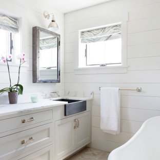 Mid-sized country master beige floor, single-sink and shiplap wall freestanding bathtub photo in Boston with shaker cabinets, gray cabinets, white walls, an undermount sink, white countertops and a built-in vanity