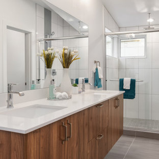 Example of a trendy 3/4 white tile gray floor bathroom design in Seattle with flat-panel cabinets, medium tone wood cabinets, white walls, an undermount sink and white countertops