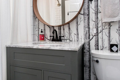Mid-sized transitional porcelain tile and white floor bathroom photo in Other with recessed-panel cabinets, gray cabinets, a two-piece toilet, white walls and an undermount sink