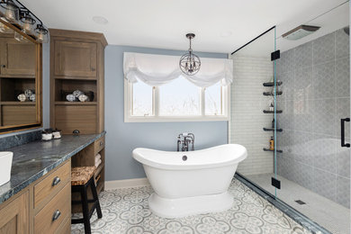 Transitional gray tile multicolored floor freestanding bathtub photo in Other with shaker cabinets, medium tone wood cabinets, blue walls, a hinged shower door and gray countertops