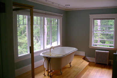 Example of a mid-sized transitional light wood floor freestanding bathtub design in Burlington with blue walls