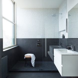 Inspiration for a mid-sized modern master black tile, gray tile and mosaic tile mosaic tile floor and black floor bathroom remodel in New York with flat-panel cabinets, white cabinets, multicolored walls, an undermount sink, marble countertops and gray countertops