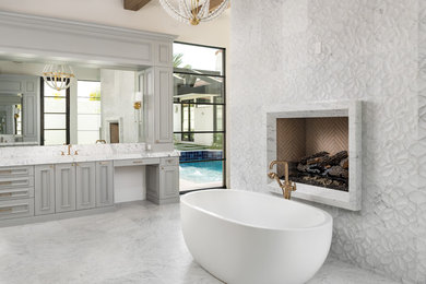 フェニックスにあるトランジショナルスタイルのおしゃれな浴室 (落し込みパネル扉のキャビネット、グレーのキャビネット、置き型浴槽、ベージュの壁、グレーの床、白い洗面カウンター) の写真
