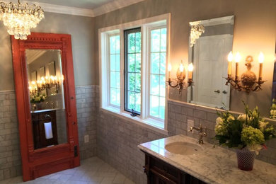 Example of a mid-sized ornate master subway tile and gray tile porcelain tile corner shower design in Indianapolis with recessed-panel cabinets, dark wood cabinets, gray walls, an undermount sink and marble countertops