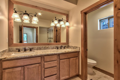 Example of a mid-sized arts and crafts bathroom design in Other with recessed-panel cabinets, medium tone wood cabinets, beige walls, an undermount sink and granite countertops