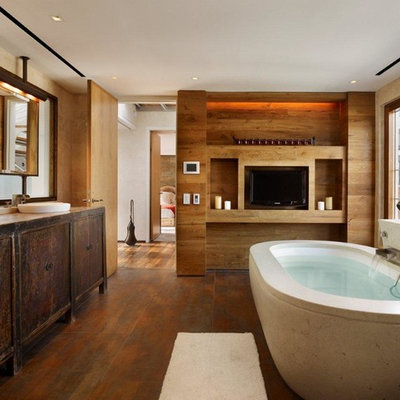 Freestanding bathtub - large industrial master medium tone wood floor and brown floor freestanding bathtub idea in New York with a vessel sink, flat-panel cabinets, dark wood cabinets and beige walls