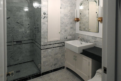 Idée de décoration pour une petite salle de bain tradition avec un placard à porte shaker, des portes de placard blanches, WC à poser, un carrelage gris, du carrelage en marbre, un mur gris, un sol en marbre, un lavabo posé, un plan de toilette en calcaire, un sol gris, une cabine de douche à porte battante et un plan de toilette noir.
