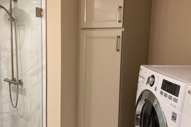 Bathroom/laundry room - small 3/4 porcelain tile, white floor and single-sink bathroom/laundry room idea in Minneapolis with recessed-panel cabinets, beige cabinets, beige walls, granite countertops, a hinged shower door and a built-in vanity