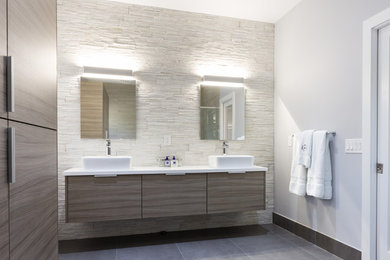 Example of a large minimalist master porcelain tile and beige tile porcelain tile bathroom design in Miami with a vessel sink, flat-panel cabinets, gray cabinets, quartz countertops, a one-piece toilet and white walls