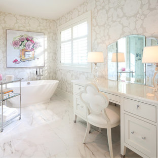 Ispirazione per una grande stanza da bagno padronale tradizionale con consolle stile comò, vasca freestanding, pareti beige, ante bianche e pavimento in marmo