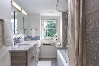 Large trendy master blue tile and mosaic tile ceramic tile bathroom photo in Seattle with flat-panel cabinets, light wood cabinets, a one-piece toilet, white walls, solid surface countertops and an undermount sink
