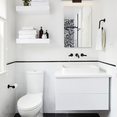 Inspiration for a small contemporary 3/4 white tile black floor bathroom remodel in DC Metro with flat-panel cabinets, white cabinets, white walls, a vessel sink and white countertops