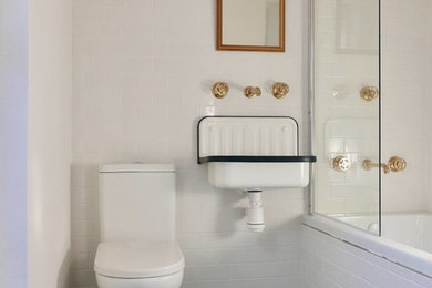 Photo of a small contemporary bathroom in Other with a shower/bath combination, a one-piece toilet and black floors.