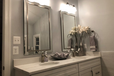 Inspiration for a mid-sized transitional master gray tile and marble tile yellow floor and double-sink bathroom remodel in Baltimore with shaker cabinets, white cabinets, a two-piece toilet, gray walls, an undermount sink, quartz countertops, white countertops and a built-in vanity