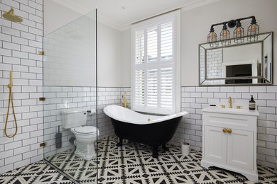 Inspiration for a traditional shower room bathroom in London with recessed-panel cabinets, white cabinets, a claw-foot bath, a built-in shower, white tiles, metro tiles, grey walls, a submerged sink, multi-coloured floors, an open shower and white worktops.