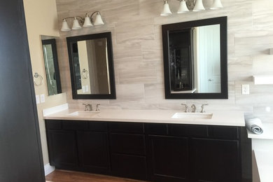 Bathroom - mid-sized contemporary master gray tile and porcelain tile medium tone wood floor bathroom idea in Las Vegas with recessed-panel cabinets, dark wood cabinets, an undermount sink and quartz countertops