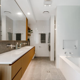 Photo of a contemporary master bathroom in Brisbane with furniture-like cabinets, light wood cabinets, an undermount tub, an alcove shower, a wall-mount toilet, gray tile, porcelain tile, grey walls, porcelain floors, an undermount sink, engineered quartz benchtops, grey floor, an open shower, white benchtops, a shower seat, a double vanity and a floating vanity.