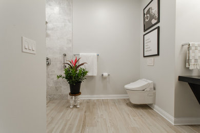 Example of a mid-sized transitional master white tile and marble tile porcelain tile, beige floor and single-sink bathroom design in Cleveland with flat-panel cabinets, black cabinets, a wall-mount toilet, beige walls, a vessel sink, wood countertops, black countertops and a floating vanity