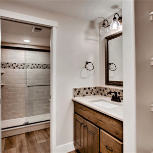 Idee per una grande stanza da bagno con doccia stile americano con ante con bugna sagomata, ante in legno bruno, doccia alcova, piastrelle beige, piastrelle in gres porcellanato, pareti beige, pavimento con piastrelle effetto legno, lavabo sottopiano, top in quarzite, pavimento marrone, porta doccia scorrevole, top beige, panca da doccia, un lavabo e mobile bagno incassato