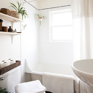 Inspiration for a small midcentury bathroom in Portland with a pedestal sink, a claw-foot tub, white walls and linoleum floors.