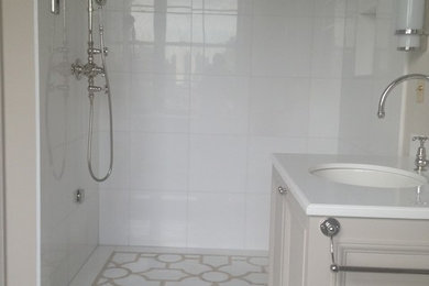 Inspiration for a mid-sized timeless 3/4 white tile, beige tile and porcelain tile porcelain tile and white floor bathroom remodel in New York with beige walls, an undermount sink, marble countertops, raised-panel cabinets, beige cabinets and a one-piece toilet
