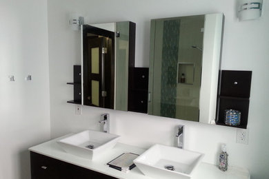 Modelo de cuarto de baño moderno de tamaño medio con armarios con paneles lisos, puertas de armario negras, paredes azules, suelo de baldosas de cerámica, lavabo sobreencimera, encimera de cuarcita y suelo beige