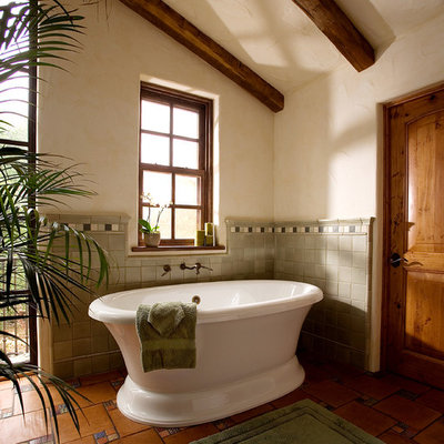 Large southwest master terra-cotta tile freestanding bathtub photo in Santa Barbara with beige walls