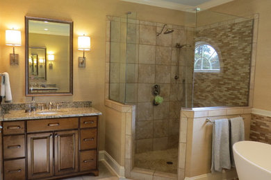 シャーロットにあるお手頃価格の広いトランジショナルスタイルのおしゃれな浴室 (置き型浴槽、茶色いタイル、ベージュの壁、オーバーカウンターシンク、濃色木目調キャビネット、コーナー設置型シャワー、セラミックタイルの床) の写真