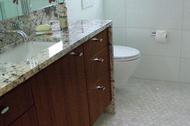 Exemple d'une grande salle de bain chic en bois foncé avec un placard à porte plane, un carrelage blanc, des carreaux de porcelaine, un mur beige, un sol en marbre, un lavabo encastré, un plan de toilette en granite, un sol gris et une cabine de douche à porte battante.