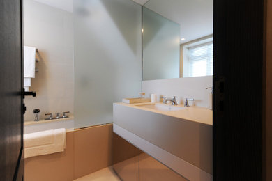 ロンドンにあるラグジュアリーな中くらいなコンテンポラリースタイルのおしゃれな浴室 (フラットパネル扉のキャビネット、アルコーブ型浴槽、ベージュのタイル、ベージュの壁、セラミックタイルの床、洗面台1つ) の写真