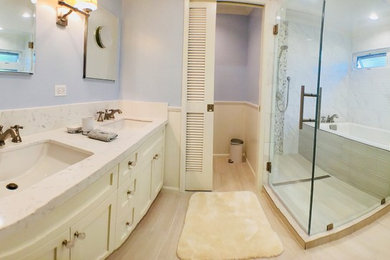 Design ideas for a large traditional bathroom in Hawaii with shaker cabinets, white cabinets, engineered stone worktops, a built-in bath, a shower/bath combination, white tiles, marble tiles, blue walls, light hardwood flooring, a submerged sink, beige floors, a shower curtain and white worktops.
